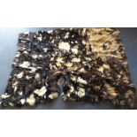 A large buffalo hide rug in blacks, whites and browns, length 224cm, width 160cm.