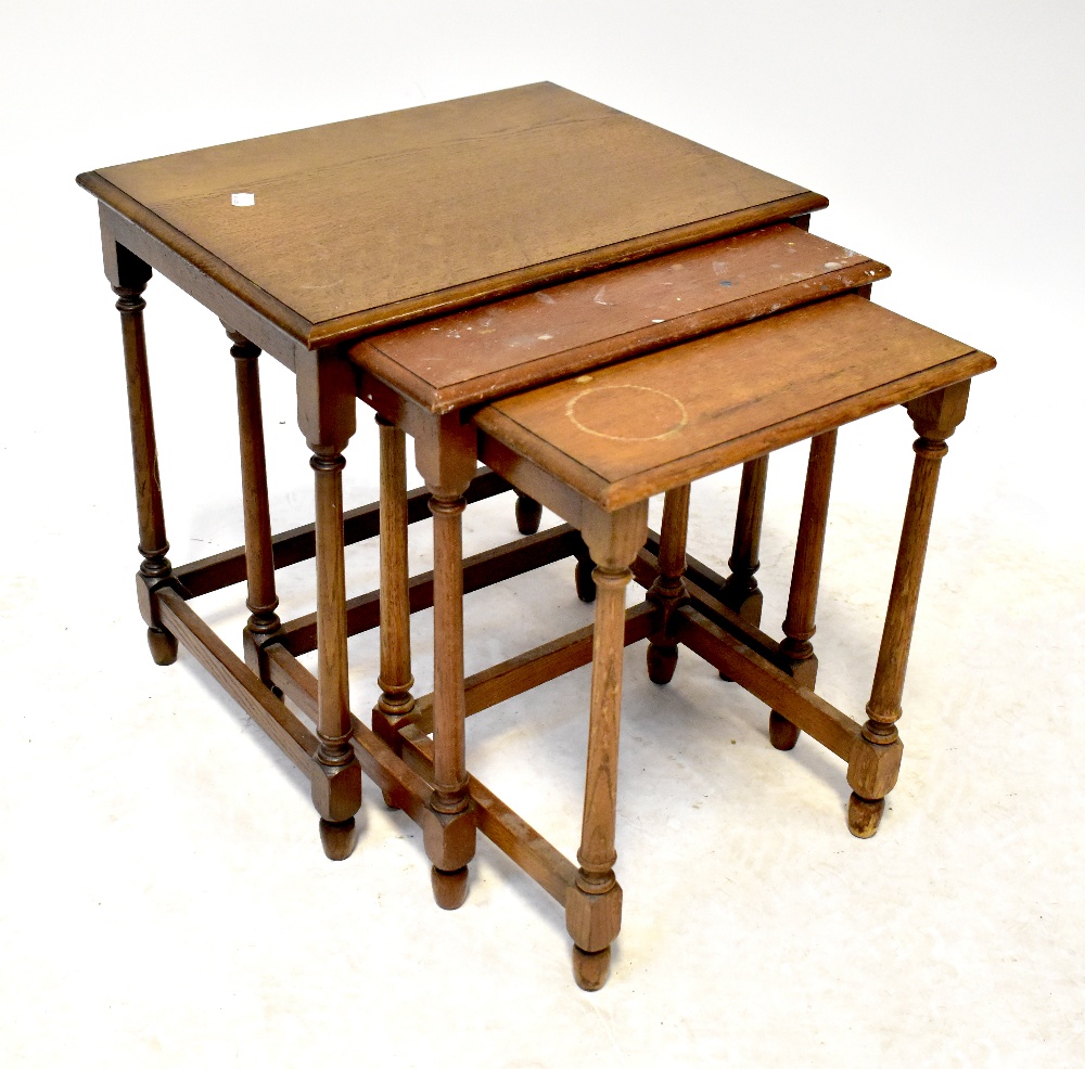 A nest of three oak rectangular occasional tables raised on ring turned and block supports.