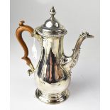 A George III hallmarked silver coffee pot with scroll fruitwood handle and mythical creature spout,