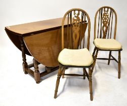 A reproduction oak gateleg dining table raised on turned and block stretchered supports and a set