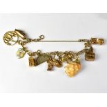 A yellow metal triple hoop link charm bracelet with eleven charms, mostly marked for 9ct,