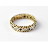 A 9ct gold eternity ring with tiny blue sapphires separating tiny white stones,