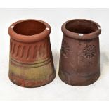 Two similar terracotta chimney tops, one with floral decoration, the other with ribbed decoration,