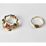 A 9ct gold open circular brooch with a small floral design of three claw set rubies and two small