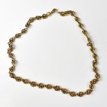A yellow metal necklace of fancy double hoop design,
