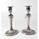 A pair of Elizabeth II hallmarked silver column candlesticks to oval beaded and shell bases,