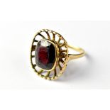 A 9ct gold garnet ring, the bezel set central garnet within an outer caged border, size K, approx 4.
