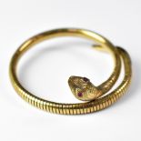 A 9ct gold coiled bracelet in the form of a snake, with ruby eyes and textured skin,