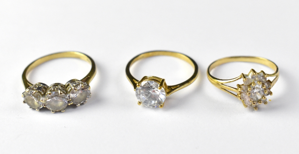 Three 9ct gold white stone dress rings, comprising a flower cluster with split shoulders, size O,