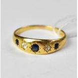 An 18ct yellow gold ring set with three star set sapphires, with two tiny diamonds in between,