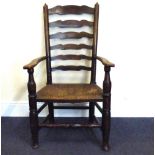 A 19th century Lancashire ladder back open armchair with rush seat and bobbin turned stretcher.