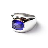 An 18ct white gold gentlemen's ring set with a central tanzanite in a cruciform setting,