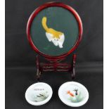 A 20th century Oriental table screen with embroidered cat to the centre of the circular glass panel,