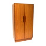 G PLAN; a teak Fresco double wardrobe with clothes rail, shelves and drawers,