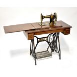 A Jones mahogany and iron sewing table, the lift-up top containing a Jones treadle sewing machine,
