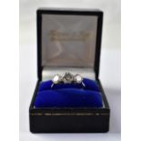 An 18ct white gold ring, the principal claw set diamond, approx 1ct,