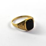A gentlemen's vintage 9ct gold signet ring with black onyx inset top with textured shoulders,