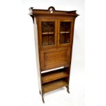 An Arts and Crafts style oak bureau bookcase with leaded cabinet doors and fitted interior,