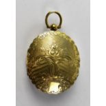A Victorian silver gilt double oval locket with engine turned pattern, floral detail front and back,