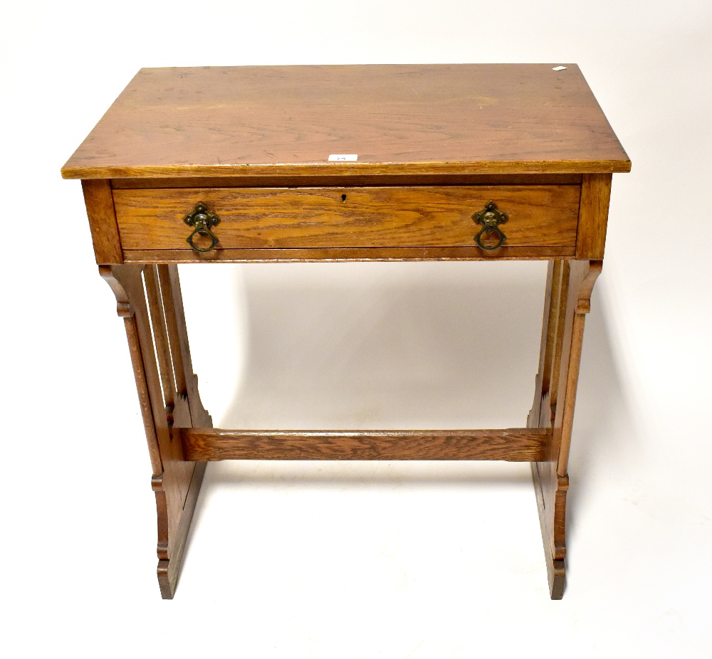 An oak single-drawer side table with Gothic-style supports united by a stretcher, 84 x 76 x 45cm.