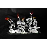 SWAROVSKI; four various birds comprising, a stork carrying a basket with a baby,