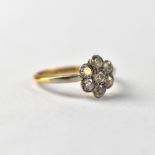 A yellow gold ring set with seven small bezel set diamonds in flower head arrangement, size M,