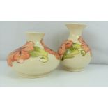 MOORCROFT; two 'Hibiscus' pattern ivory ground vases, one of baluster shape, height 14cm,