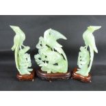 A pair of Oriental jade-style exotic birds on flowering branches, on wooden stands, height 21cm,