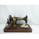 A late 19th/early 20th century hand cranked sewing machine 'The Unique Machine' with all-over gilt
