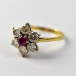 An 18ct gold ring with central claw set ruby within a flower setting of six small claw set diamonds,