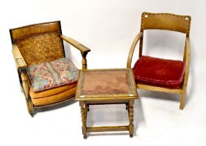 A 1930s oak low open armchair with woven leather back rest,