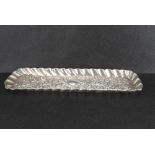 A Victorian hallmarked silver pen tray with repoussé floral and swag design and shaped outer apron,