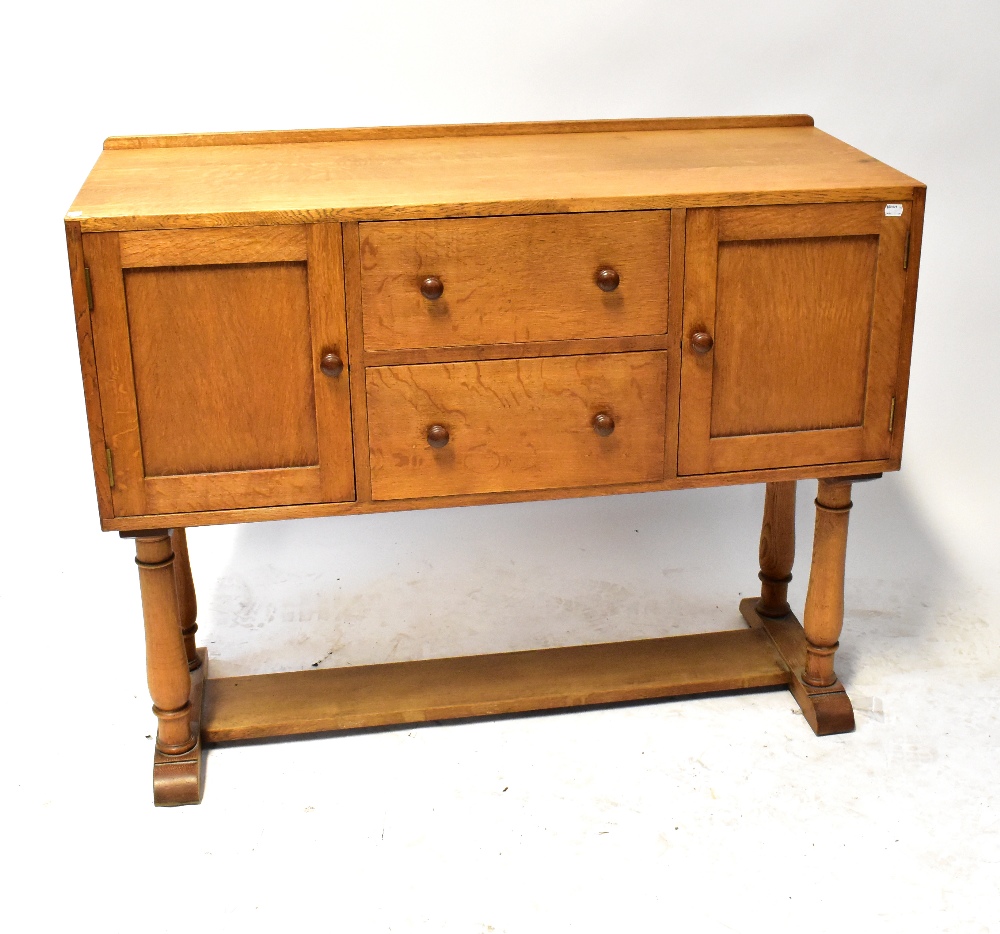 HEALS OF LONDON; an oak sideboard with a pair of drawers flanked by cupboard doors,