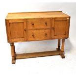 HEALS OF LONDON; an oak sideboard with a pair of drawers flanked by cupboard doors,