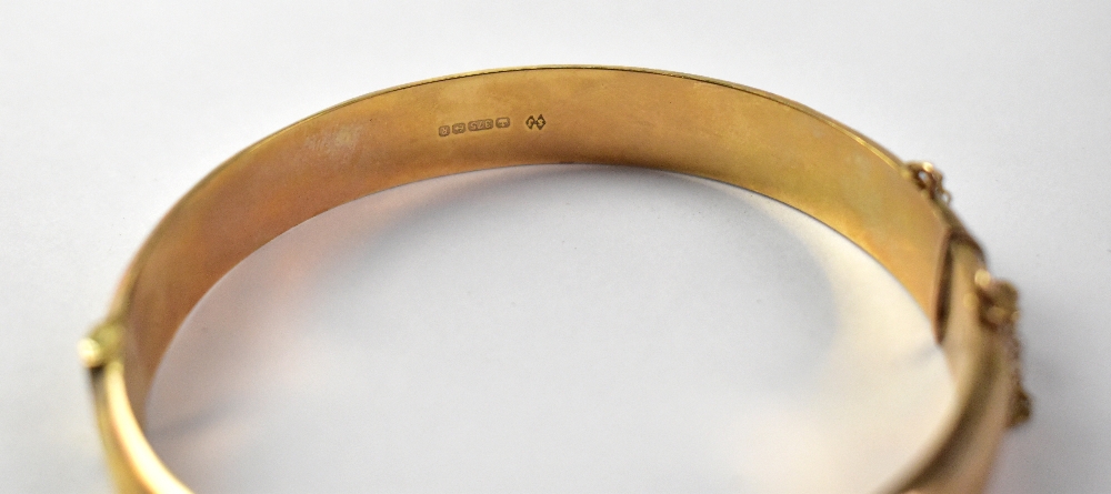 A 9ct yellow gold bangle with chased scroll decoration and safety chain, approx 11.5g. - Image 3 of 4