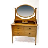 An Edwardian dressing chest with oval mirror above a single drawer,