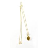 An 9ct yellow gold fine link chain with amber drop pendant, combined approx 2g.