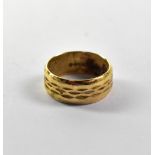A 9ct gold band with centred wavy band decoration, size M, approx 5g.