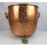 A large copper coal bucket with riveted base and two lion mask ring handles,
