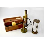 A brass monocular microscope with various accessories, fitted in a wooden case, height 29cm,