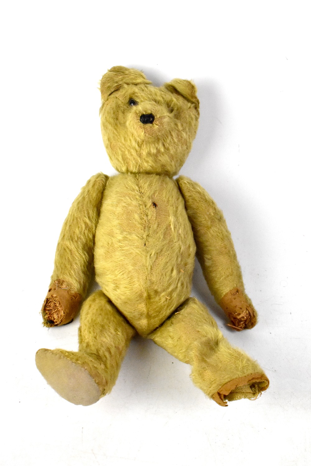 An early 20th century straw-filled teddy bear in the style of Steiff.