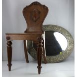 A large oval bevel-edged wall mirror in a repoussé pewter frame with floral and Classical swags,
