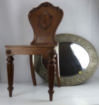 A large oval bevel-edged wall mirror in a repoussé pewter frame with floral and Classical swags,