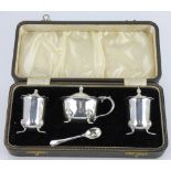 A George VI hallmarked silver cased cruet set comprising mustard, salt and pepper and spoon,