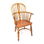 A 19th century low Windsor chair with comb back, pierced back splats, turned armrest supports,