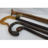 Five walking sticks to include an example with one-piece carved bull's head handle,