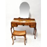 A 1930s walnut dressing table with shaped mirror and three drawers, on cabriole legs,