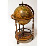 A reproduction drinks cabinet in the form of a globe, to turned supports with lower storage shelf,