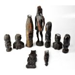 A small collection of African wooden carvings, comprising a standing figure and a variety of busts,
