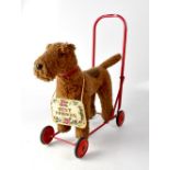 TRI-ANG; a push-along dog toy modelled as an Airedale Terrier, on a red frame, height 51cm.